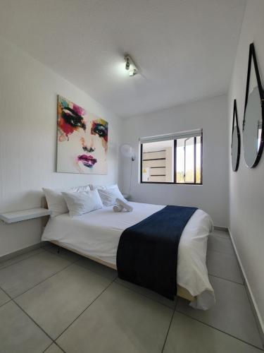 a bedroom with a large white bed and a window at Nova Luxury Suites Broadacres in Chartwell