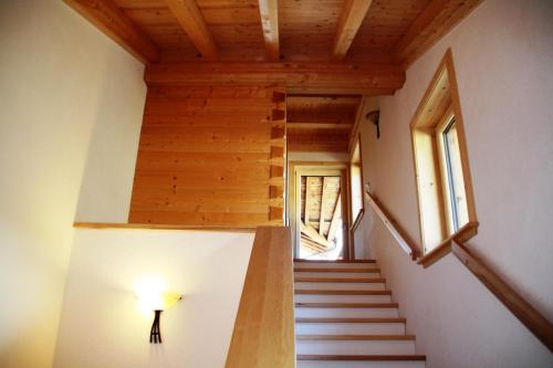 a staircase in a house with a wooden ceiling at Chalet Huter in Wenns