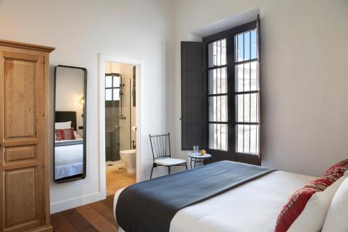 a bedroom with a bed and a bathroom at Palacete Molina in Seville