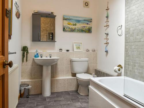 a bathroom with a toilet and a sink and a tub at The Boathouse in Appledore