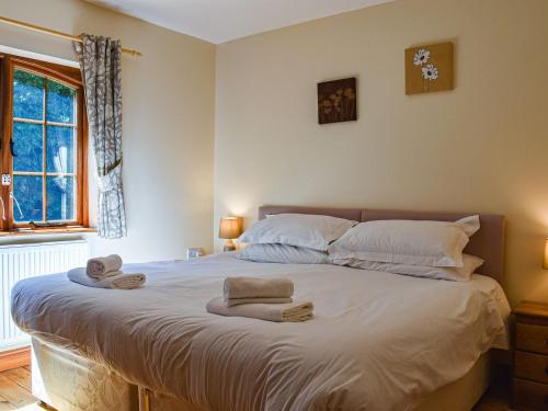 a bedroom with a large white bed with towels on it at Poppy Cottage - Uk40102 in Dunvant