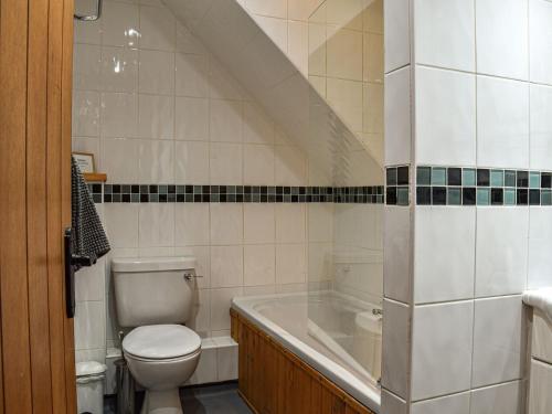 a bathroom with a toilet and a bath tub at Poppy Cottage - Uk40102 in Dunvant
