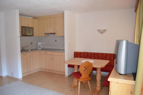 a small kitchen with a small table and a television at Lärchenhof in Leutasch