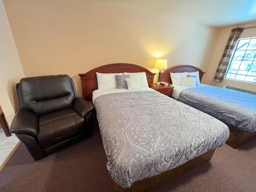 a hotel room with two beds and a chair at Frazier View Motel in Frazier Park