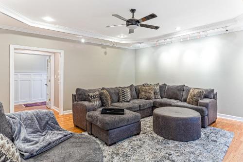 a living room with a couch and a ceiling fan at Amazing Home w/ Huge Pool, Game Tables, Movie room, and More! in Fayetteville
