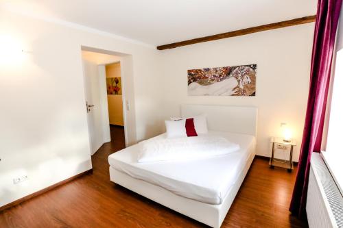 a bedroom with a white bed in a room at Pension Ferber in Monheim