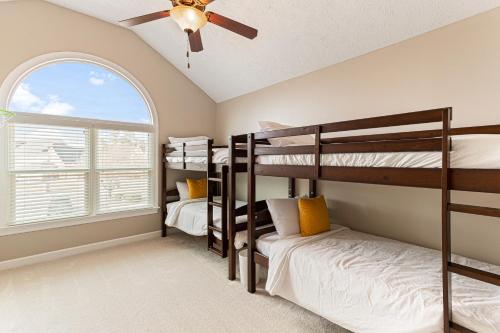 a bedroom with bunk beds and a ceiling fan at Amazing Home w/ Huge Pool, Game Tables, Movie room, and More! in Fayetteville