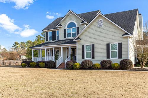 a house with a yard in front of it at Amazing Home w/ Huge Pool, Game Tables, Movie room, and More! in Fayetteville