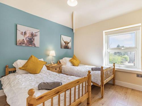a bedroom with two beds and a window at Spa Cottage in Bakewell