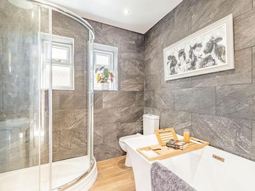 a bathroom with a shower and a toilet and a sink at Spa Cottage in Bakewell