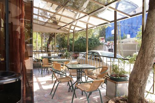 un patio con mesas y sillas bajo una pérgola en Hotel Lobelia en Addis Abeba