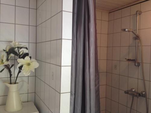 a bathroom with a vase with flowers in it at Kildegaarden Bed & Breakfast in Frørup