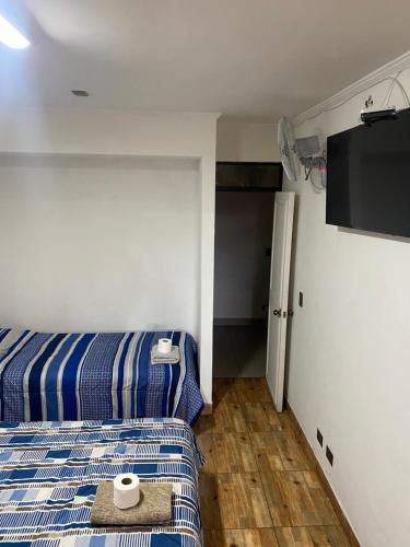 a hotel room with two beds and a flat screen tv at Apart Hotel Vicencio Iquique in Iquique