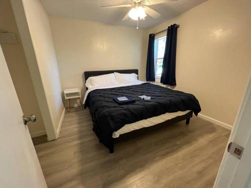 1 dormitorio con 1 cama y ventilador de techo en Modern 3-Bedroom Home with Cal-Kings Beds, 