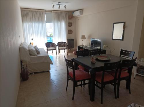 uma sala de estar com uma mesa e cadeiras e um sofá em Opción B em Chivilcoy