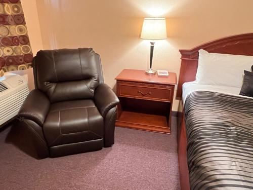 a hotel room with a chair next to a bed at Frazier View Motel in Frazier Park