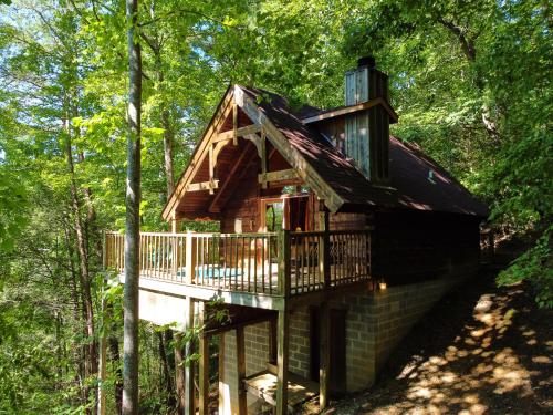 uma casa na árvore com um deque na floresta em Gatlinburg Adventure Cabins em Sevierville