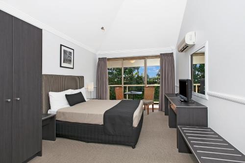 a bedroom with a bed and a television and a desk at Comfort Inn & Apartments Northgate Airport in Brisbane