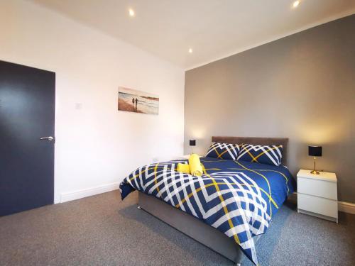 a bedroom with a bed with a blue and white comforter at Spacious Townhouse 5 Mins to Liverpool City Centre With Free Parking in Liverpool