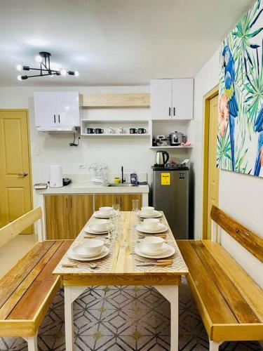 a kitchen with a wooden table with plates on it at Spacious 2 bedroom 42sqm condo unit in Iloilo City