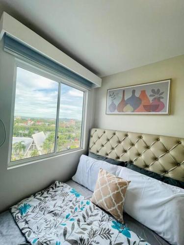 a bedroom with a bed and a large window at Spacious 2 bedroom 42sqm condo unit in Iloilo City