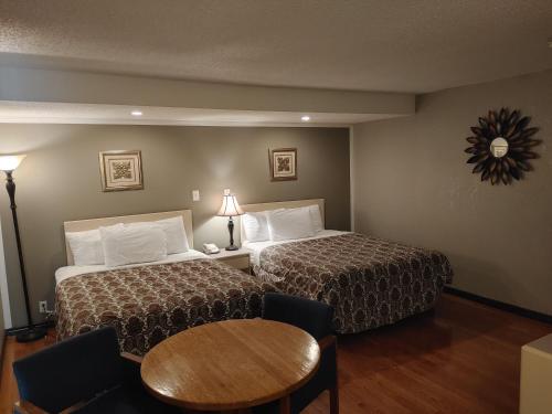 a hotel room with two beds and a table at Magnuson Hotel Creston in Creston