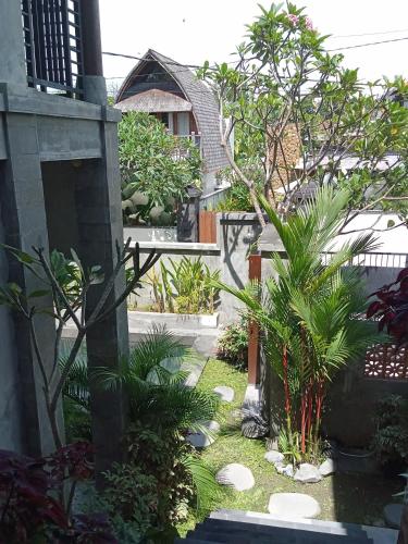 a garden with palm trees and a house at Araya villa saba in Saba