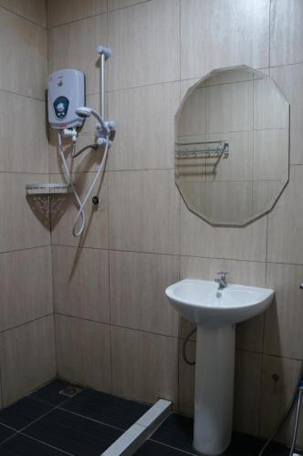 a bathroom with a sink and a mirror at Unikarya Lodge in Kota Kinabalu