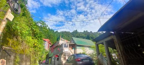 Una vista de una calle con un coche aparcado en la calle en Dik's Home, en Darjeeling