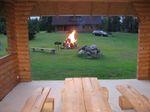 a fire pit in a cabin with benches and a campfire at Kalnakriknas in Dzimtmisa