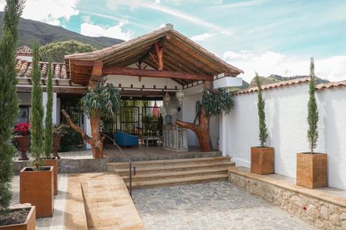 a house with a porch with a wooden roof at Hotel Boutique El Carmel in Villa de Leyva