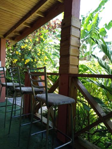 two chairs sitting on the porch of a house at Berkey's Jungle Paradise in Roseau