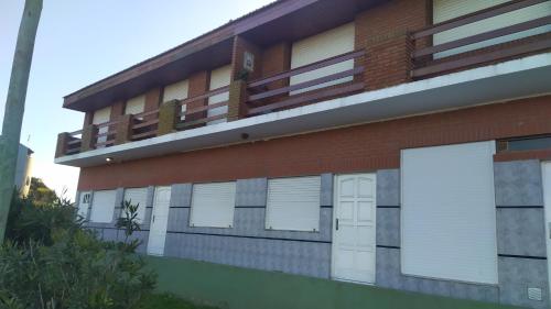 un edificio con puertas blancas y balcones. en Casa sur FARO en Mar del Plata