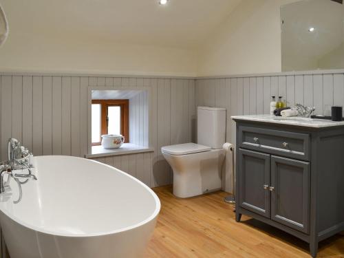 a bathroom with a tub and a sink and a toilet at Far Barsey Cottage in Sowerby Bridge