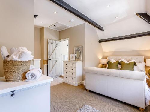a bedroom with a white couch and a white dresser at Hope Cottage in Longborough