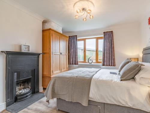 a bedroom with a bed and a fireplace at The Old Farmhouse in Longford