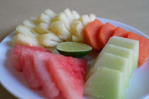 a plate of fruits and vegetables on a plate at Bali Wirasana Inn in Sanur