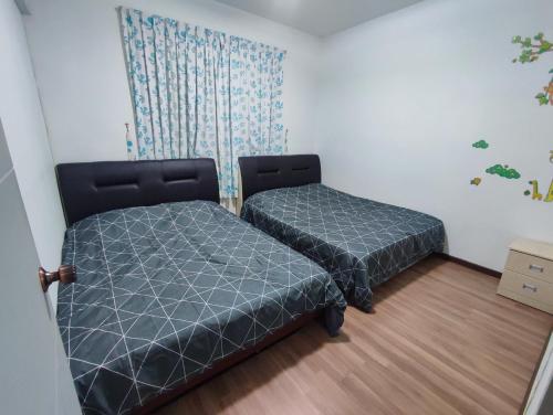 a bedroom with two beds and a curtain at Triple Z Homestay Kuching - LANDED 14 PAX in Kuching