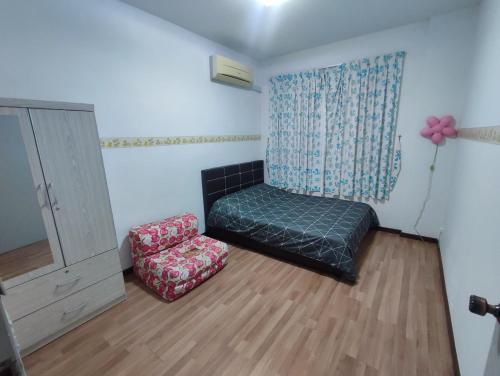 a room with a bed and a chair and a window at Triple Z Homestay Kuching - LANDED 14 PAX in Kuching