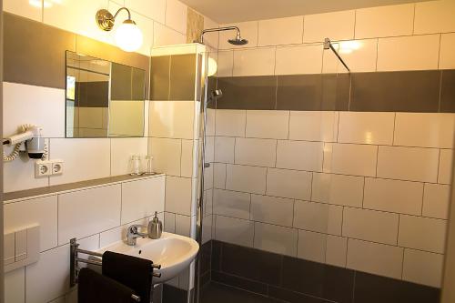 a bathroom with a sink and a shower with a mirror at Villa-Meehr in Bantikow