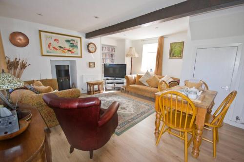 a living room with a couch and a table and chairs at Duck Cottage - Pet-friendly Traditional Rural Home in Kilrenny