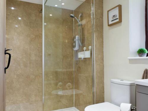 a shower with a glass door in a bathroom at Shepherds Den in Crakehall