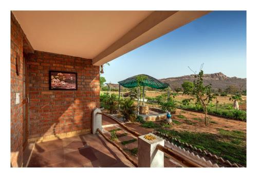 a brick building with a patio with an umbrella at Mahua hill view Homestay in Orchha
