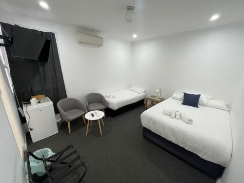 a hotel room with two beds and a tv at Central Motel Mudgee in Mudgee