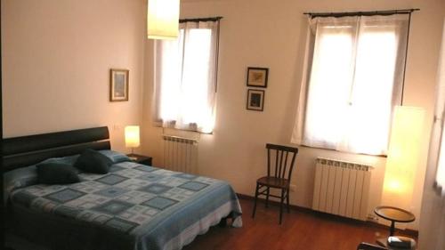a bedroom with a bed and two windows at Alvisiano in Venice