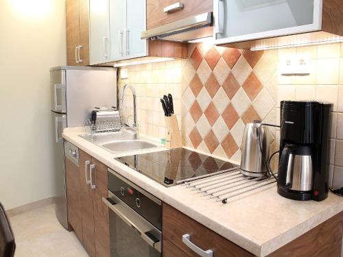 a small kitchen with a sink and a refrigerator at Vanilla Apartment 3 in Krakow