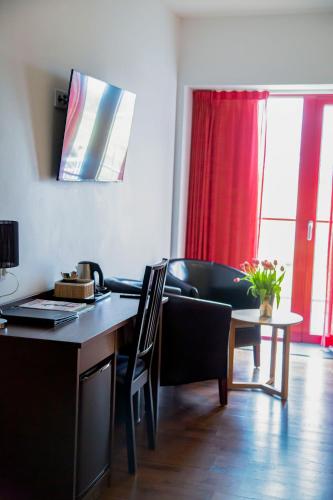 a living room with a desk and a table with a chair at Hotel Bella Luna in Båstad