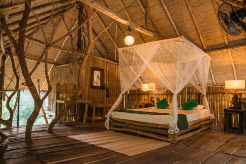 a bedroom with a bed in a room with wooden ceilings at The Saraii Tree Lodge in Tissamaharama