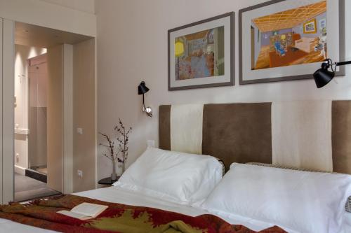 - une chambre avec un lit et deux photos sur le mur dans l'établissement MyNavona, à Rome