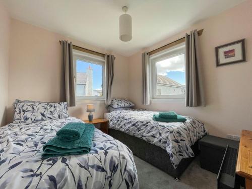 a bedroom with two beds and a window at The Old Surgery in Kinlochbervie